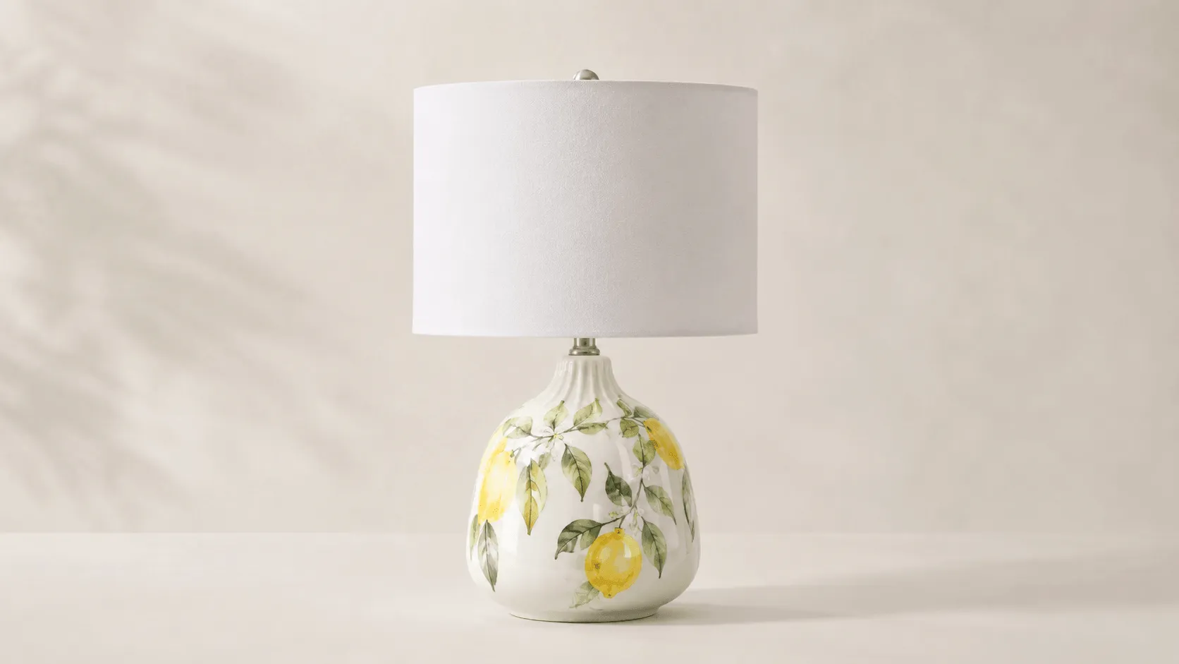 Custom ceramic decor manufacturer example showing a white table lamp with yellow fruit and green leaf patterns